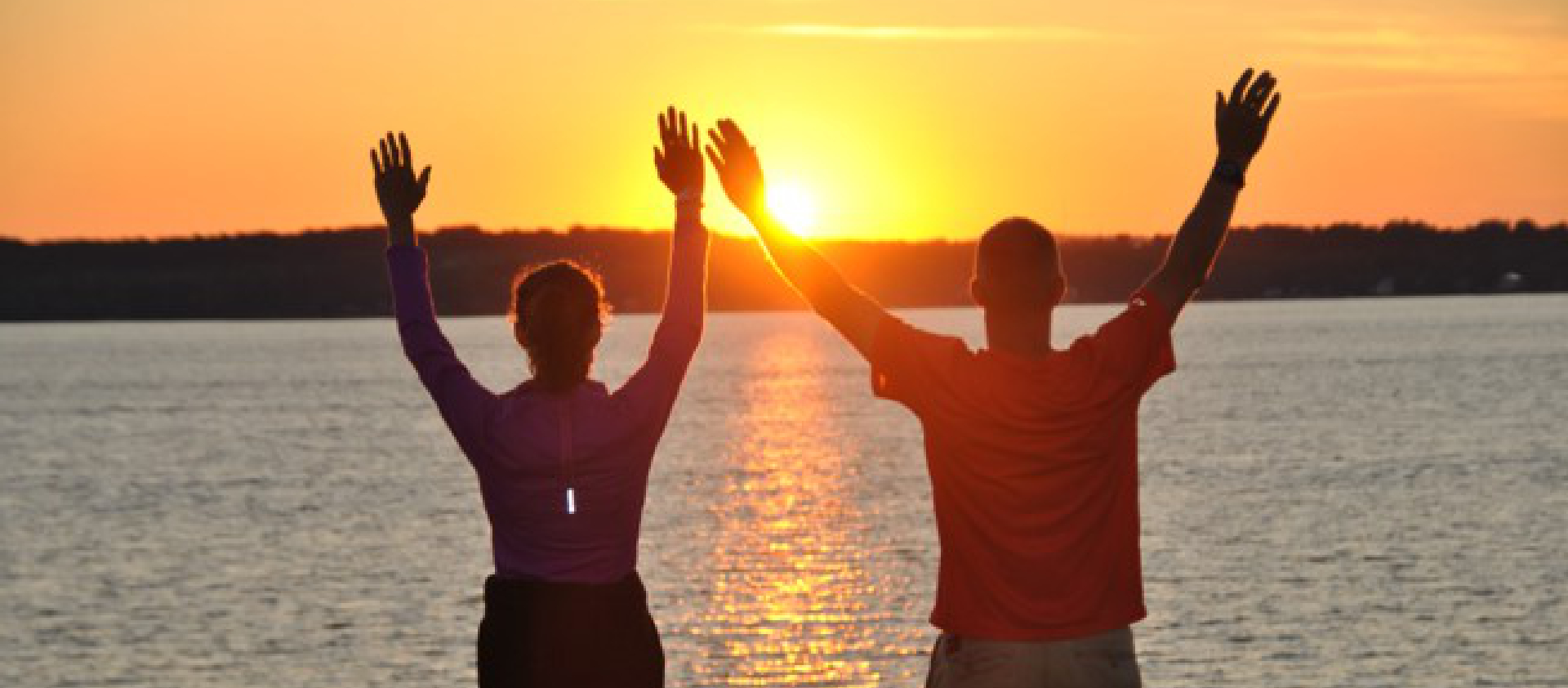 man and woman raising their hands